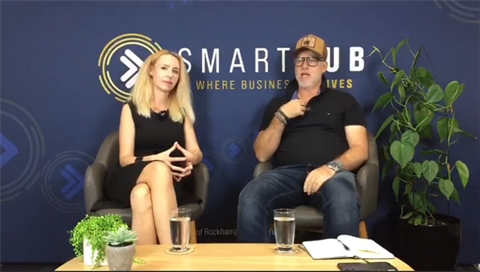 Chris Lorang and Elize sitting in front of SmartHub media wall
