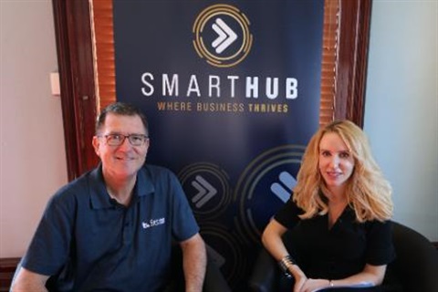 Photo of David French and Elize Hattin sitting in front of the SmartHub banner