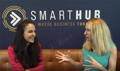 Tamara Loehr and Elize Hattin sitting on a couch in front of the SmartHub logo